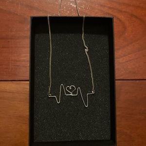 Jewelmint gold necklace with a heartbeat pendant